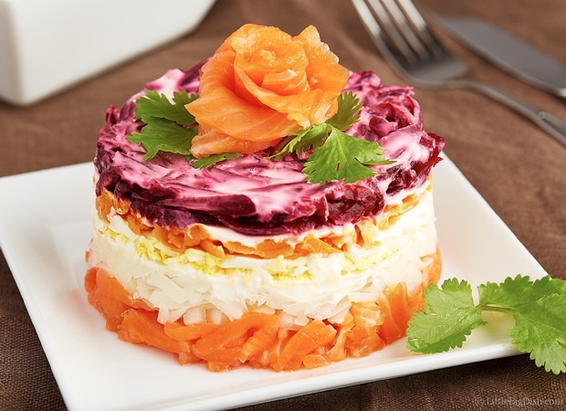 Salmon Salad Cake on a white plate garnished with fresh parsley.