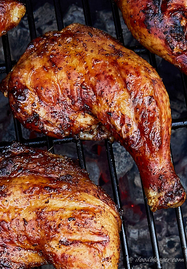 A close up of a beautifully browned grilled chicken leg.