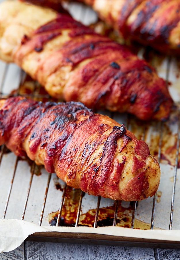 Close up of a super crispy bacon-wrapped chicken breast.