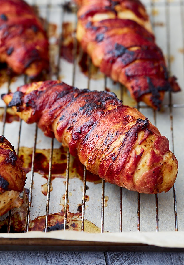 Bacon-wrapped chicken breasts on a baking sheet.