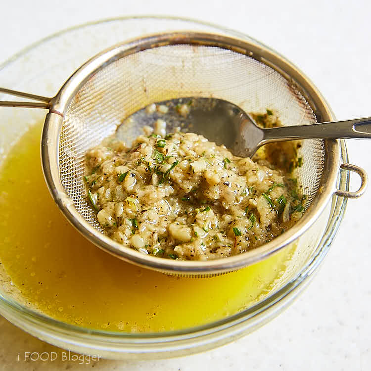 Roasted turkey breast - straining butter after infusing with herbs and garlic. | ifoodblogger.com