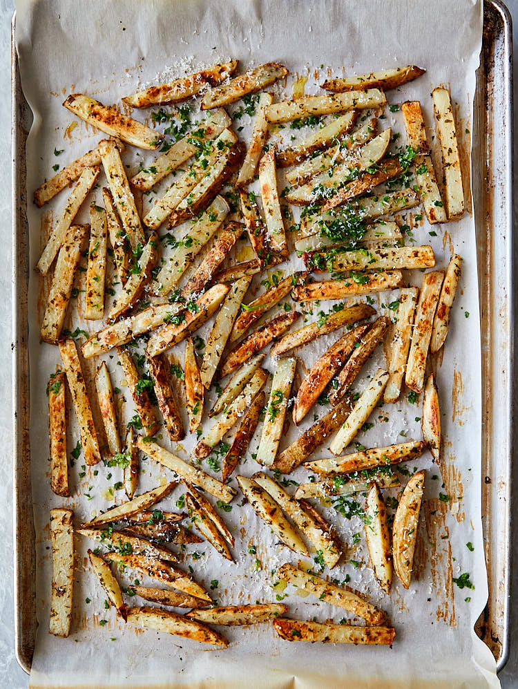 Freshly made truffle fries spread on a large baking sheet.