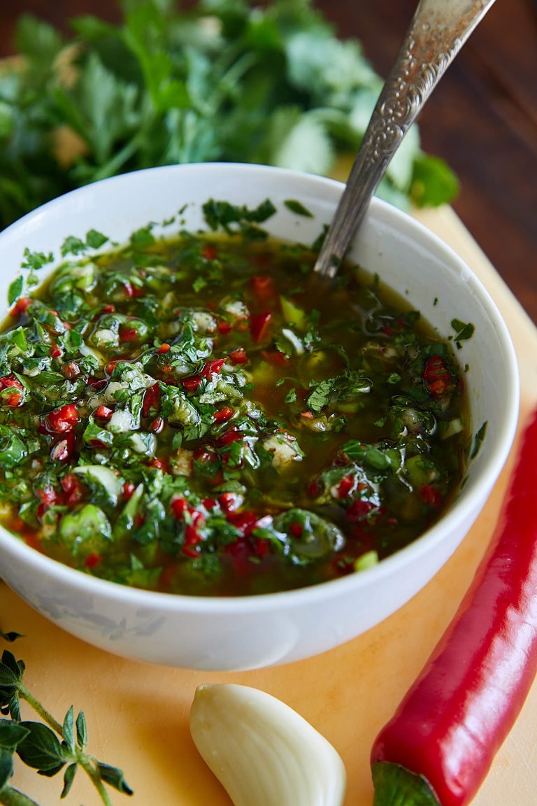 A bowl of cilantro chimichurri sauce with a spoon