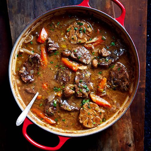 Braised beef cooked in a cast iron braising pan with mushrooms, leeks, carrots, onions, shallots and garlic. The sauce is thick and velvety smooth, like gravy. No thickening is needed after braising. Simply remove from the oven and serve with a side dish of choice. | ifoodblogger.com