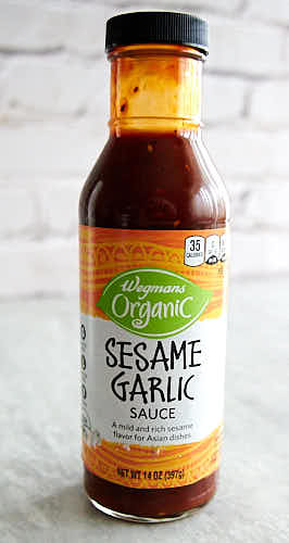 Asian sesame garlic sauce in a bottle on a table.